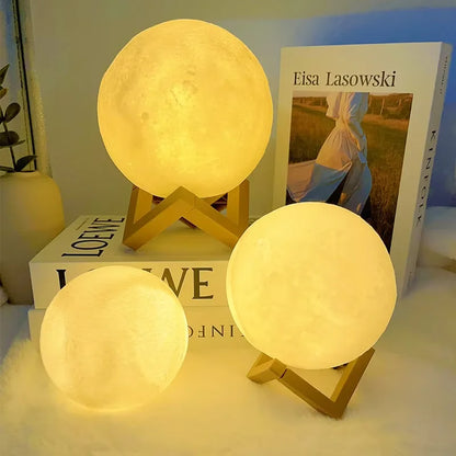 Three moon-shaped lamps on a surface with books in the background