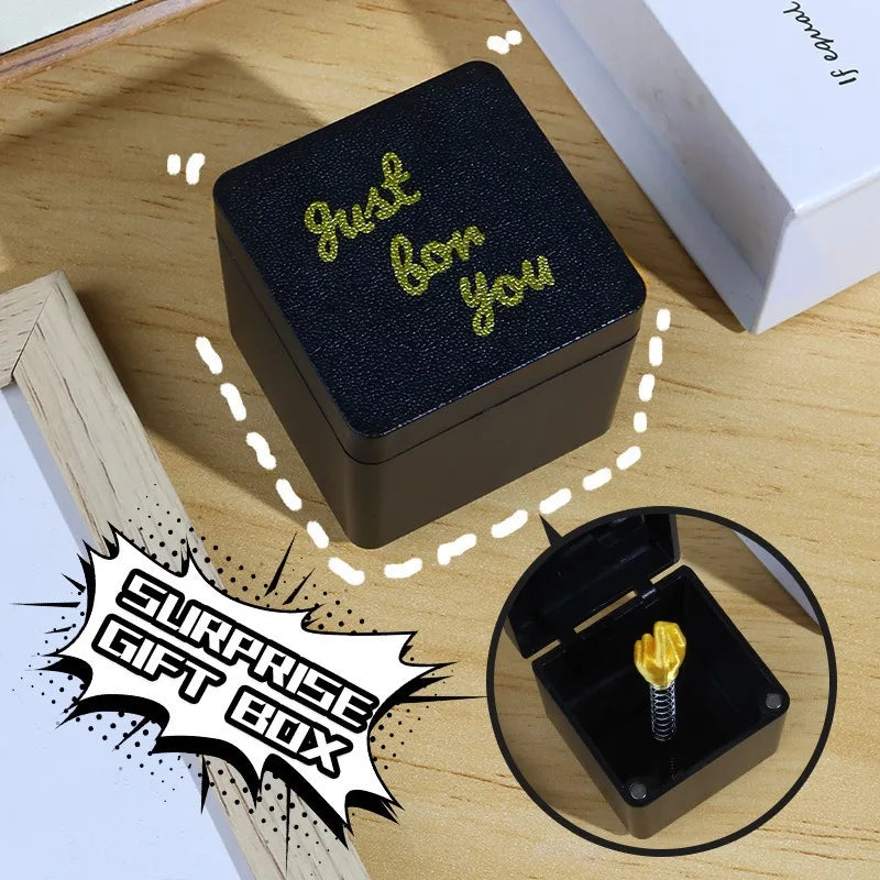 Black gift box with 'Just for you' text on a wooden surface, featuring a small gold figurine.