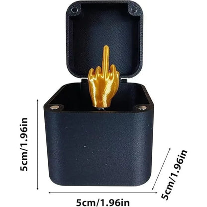 Black box with a gold middle finger figurine, showing dimensions on a white background