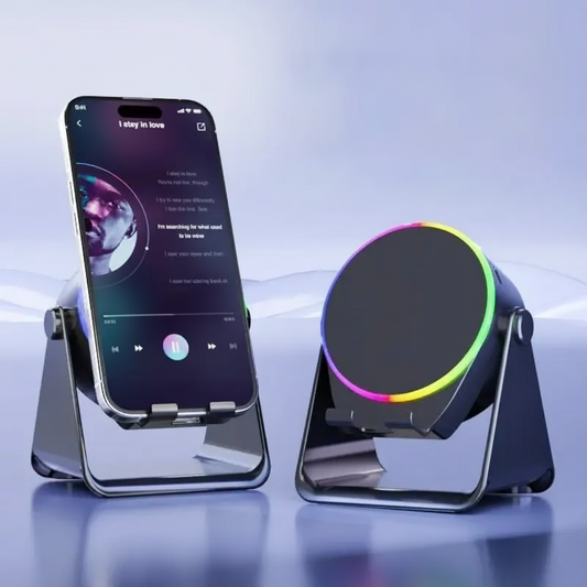 A smartphone displayed on a metallic stand beside a circular wireless charging pad with a rainbow LED ring, set against a soft blue studio background.